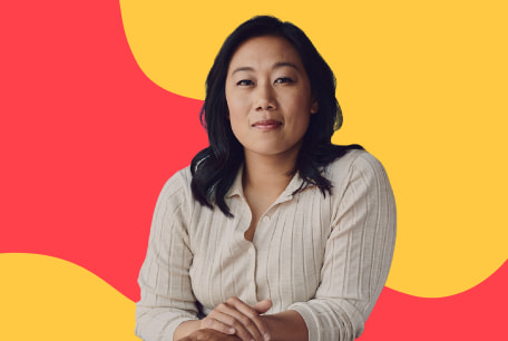 Priscilla Chan, Co-CEO of the Chan Zuckerberg Initiative looking at the camera with her arms folded and in front of a red and yellow illustrated background.